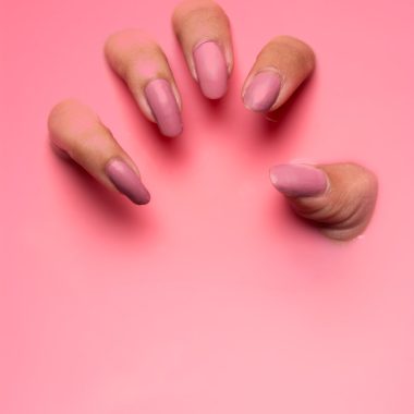 persons hand on pink surface