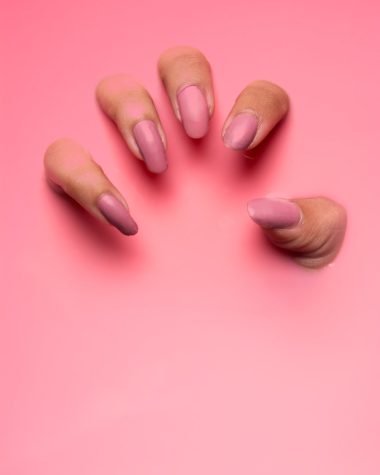 persons hand on pink surface