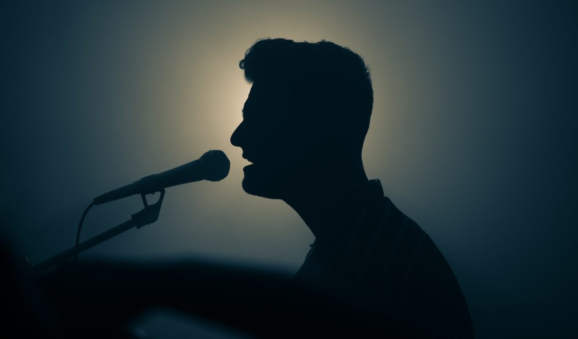 a silhouette of a man singing into a microphone