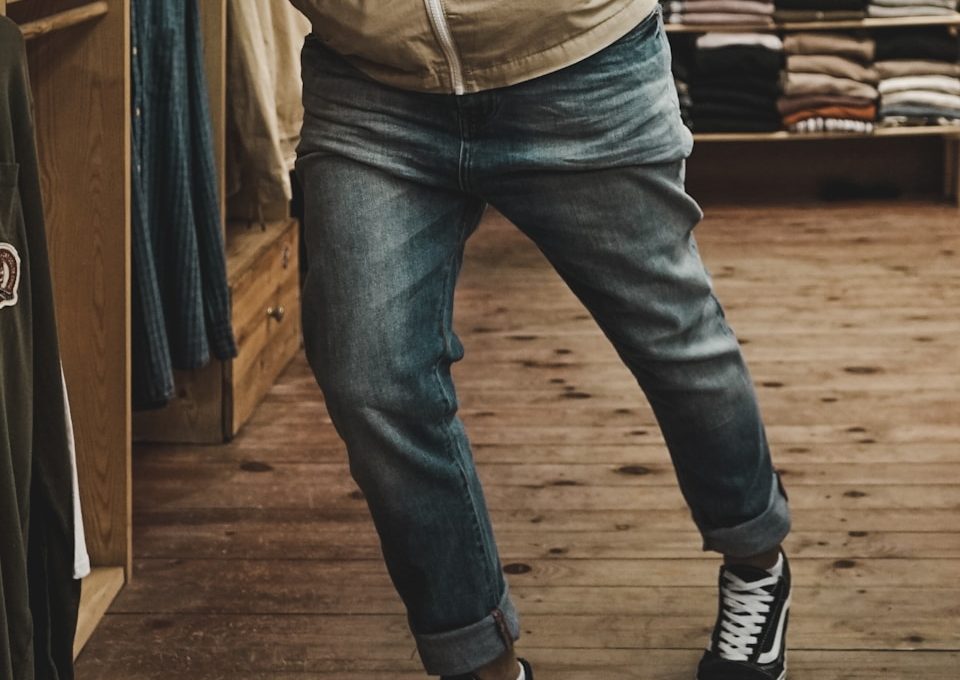 person wearing blue denim jeans and white-and-black sneakers