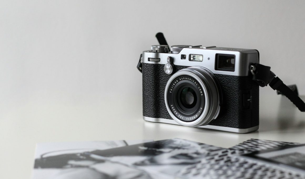 black and gray film camera near printed photos