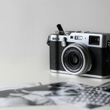 black and gray film camera near printed photos