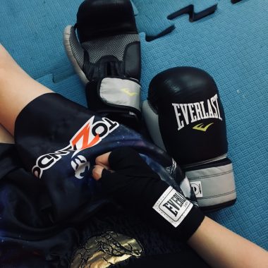 a pair of boxing gloves laying on top of a blue floor