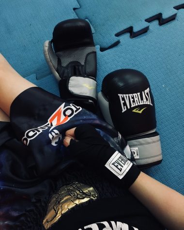 a pair of boxing gloves laying on top of a blue floor