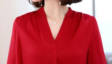 A woman in a red blouse with a necklace.