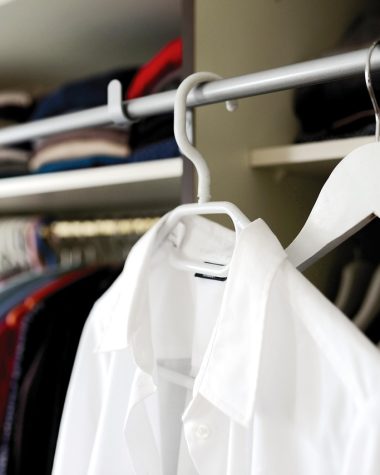 Vrouw die 's ochtends bewust een outfit kiest uit haar kledingkast