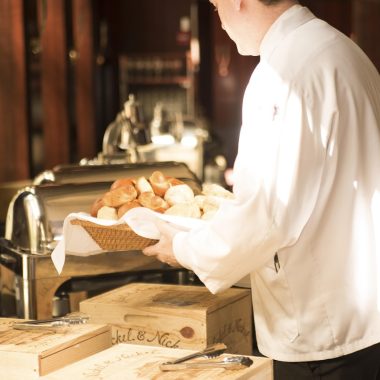 Een linnen keukenschort hangend aan een houten haak in een lichte keuken