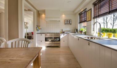 Open keuken die naadloos overgaat in de woonkamer, met geïntegreerde apparaten en een strakke uitstraling