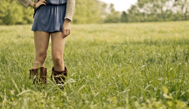 Vrouw in midi-rok met laarzen op kantoor, herfst outfiit combinatie
